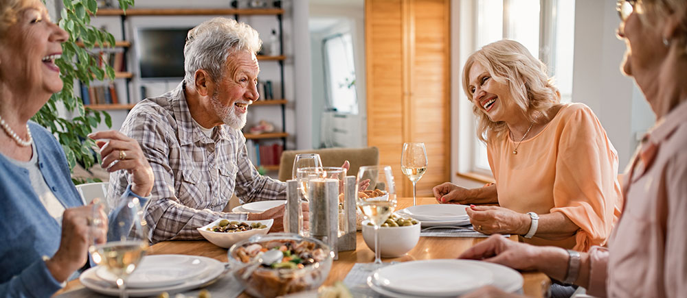 Group of senior friends eating together.