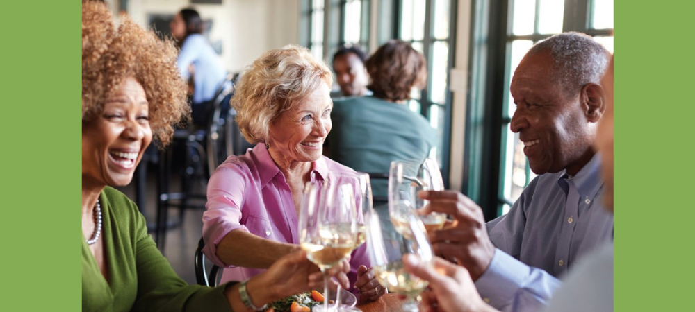 Group of men and women dining, debunking senior living stereotypes