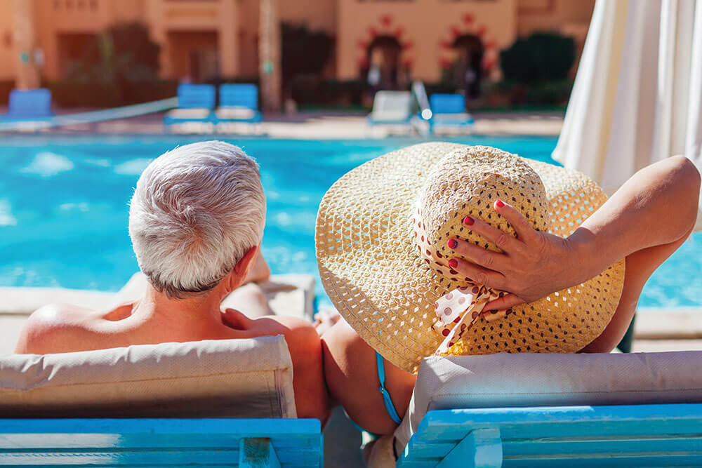 Senior couple relaxing by an outdoor pool