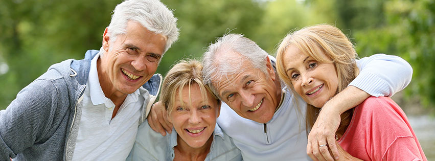 a group of senior friends laugh outside together