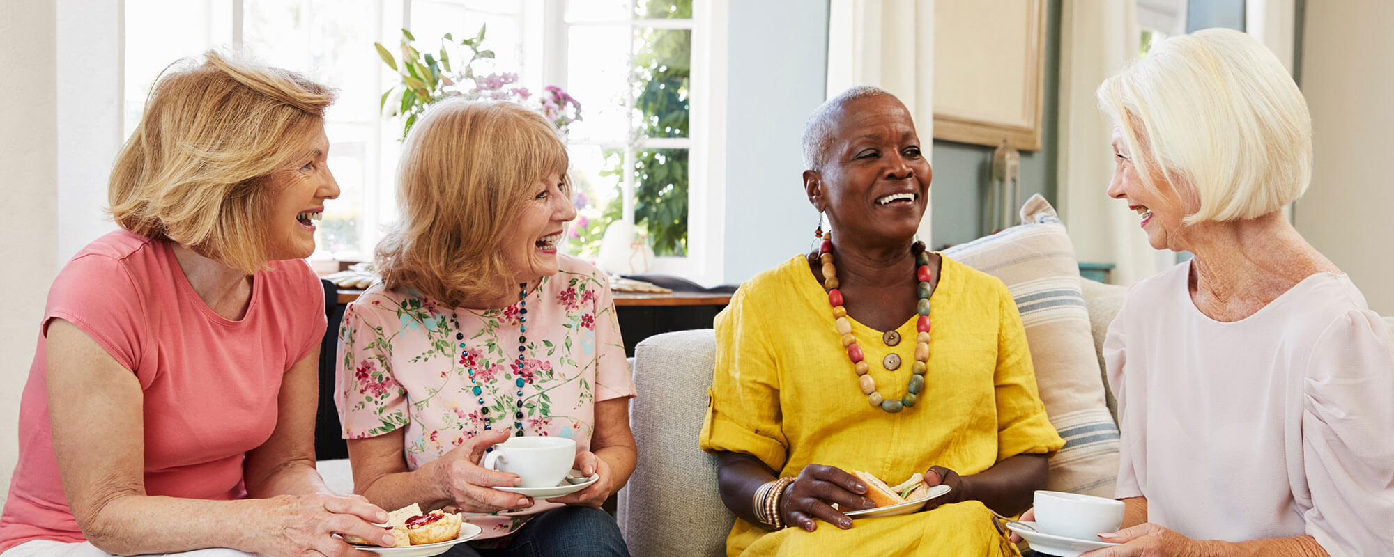 group of happy seniors drinking coffee and tea at their senior living community