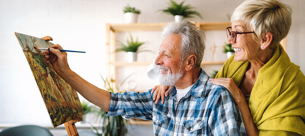 Senior couple painting in their home and expressing themselves through.