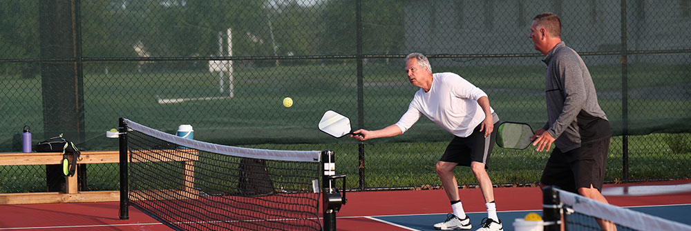 Seniors playing pickleball outdoors